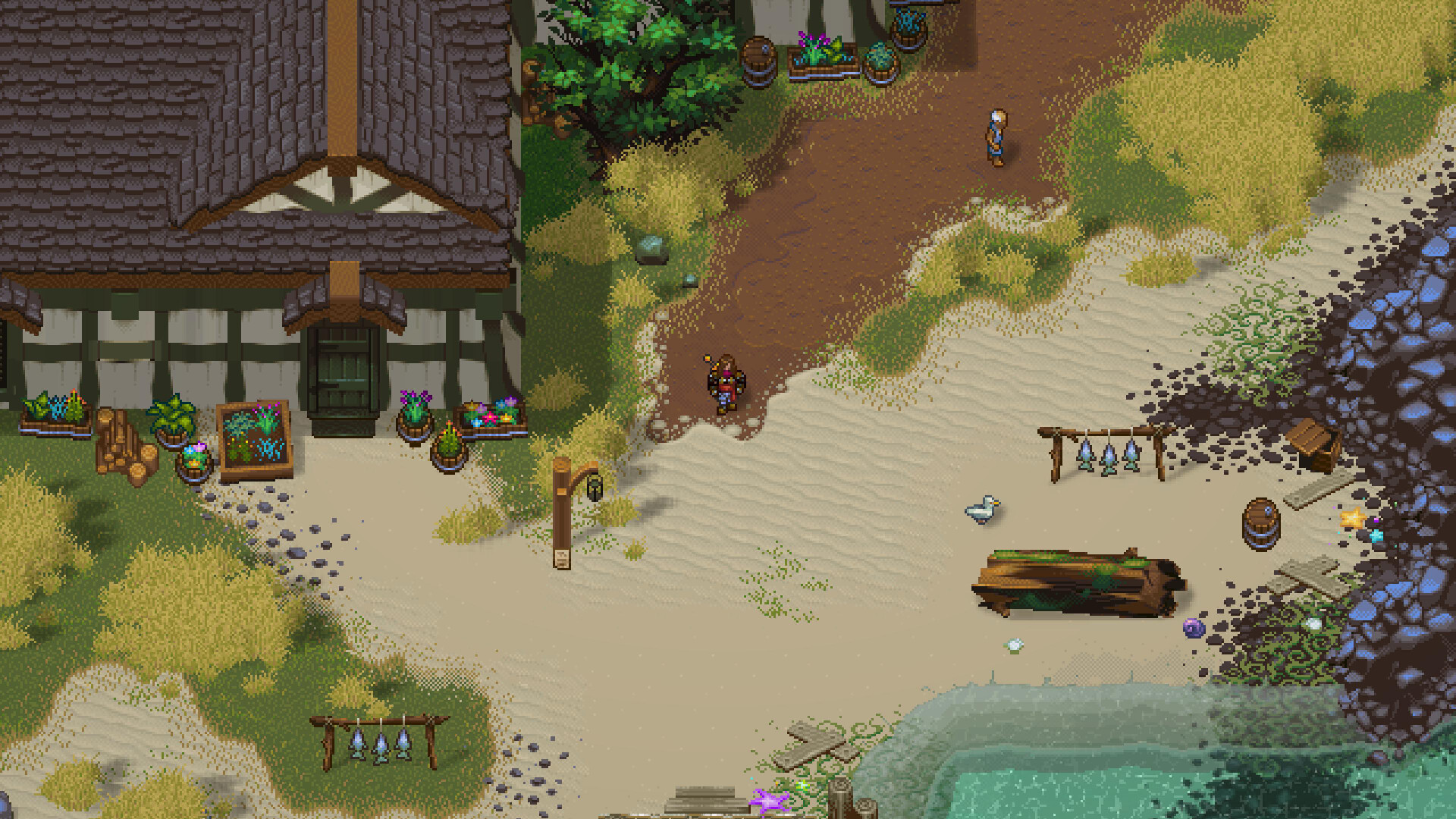 A top-down view of a village edge with a timber-framed house, flower planters, a sand path, fishing racks, barrels and a stream.